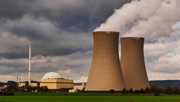 Ein Atomkraftwerk mit charakteristischen Kuppel in einer flachen Landschaft.